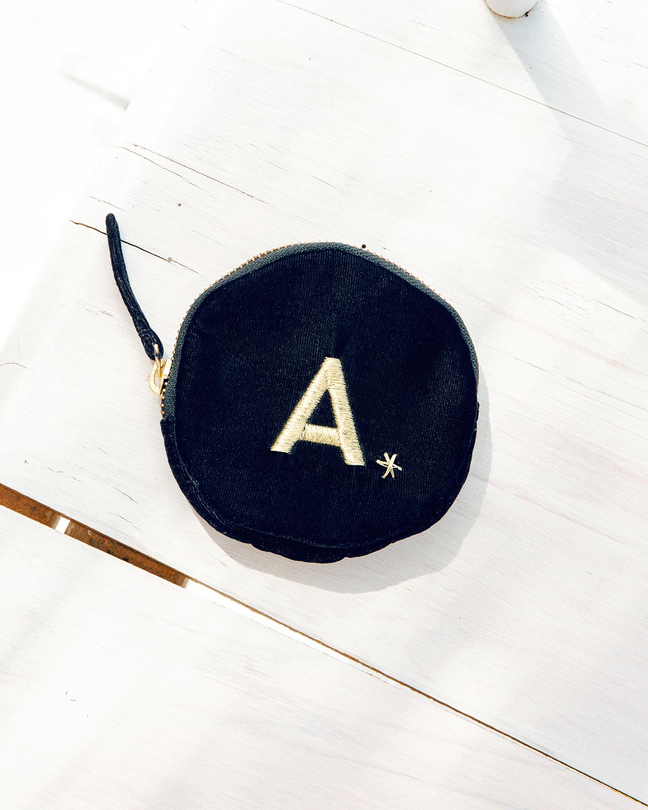 Le porte-monnaie Initiale en velours bleu nuit et broderie dorée